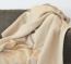 Hochwertige Heimdecke aus Cashmere und Merino-Lammwolle Heimdecke aus Cashmere und Merino-Lammwolle ausgebreitet auf einer Couch