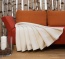 kuschelige Plüschdecke in edlem Naturton Plüschdecke in hellem Naturton ausgebreitet auf einem Sofa
