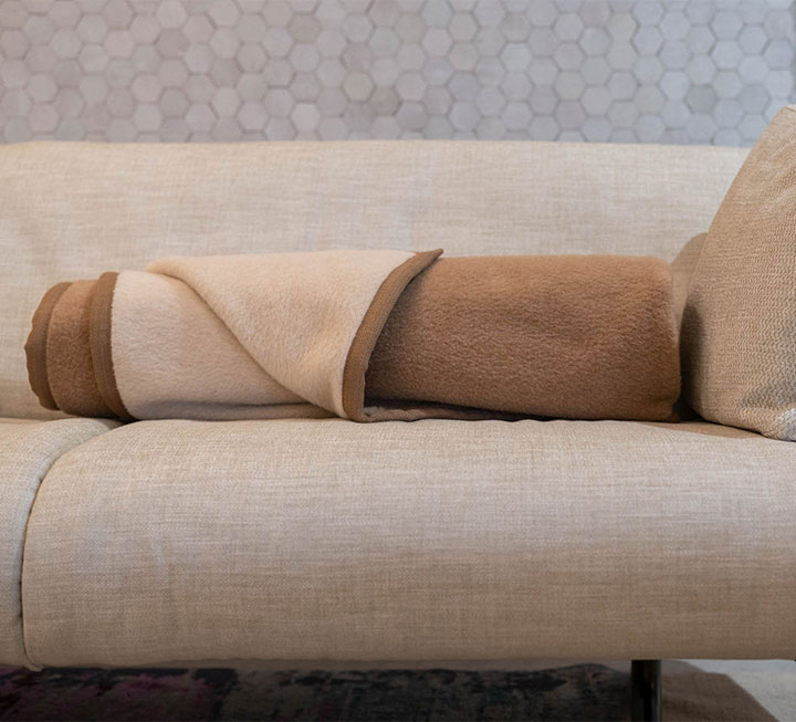 Naturhaardecke zusammengerollt auf Couch Naturhaardecke zusammengerollt auf Couch