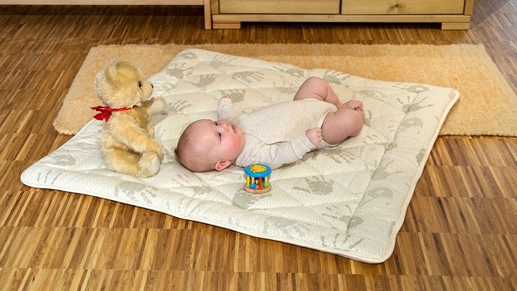Schafschurwoll-Krabbeldecke mit Baby auf dem Boden