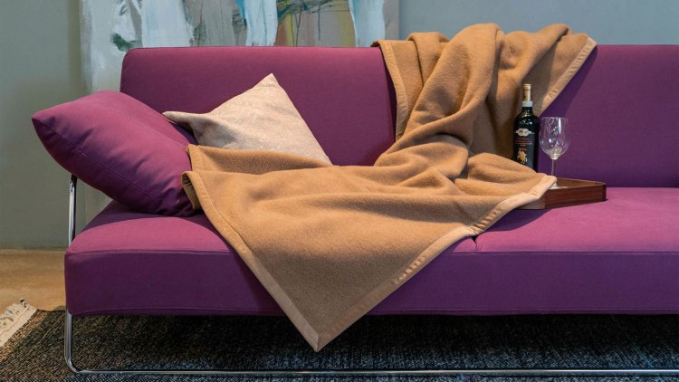 Wolldecke aus Kamelhaar in Farbe kamel, ausgebreitet auf einem Sofa