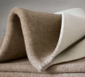 Heimelige Decke aus Merino-Schafwolle in Farbstellung beige/weiß